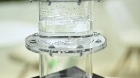 Hydrogen gas is bubbeling through a membrane in a plastic cylinder filled Stock Footage 252108190