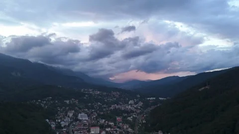 Hyper lapse aerial view of small town near the mountains at sunset Stock Footage 280099073