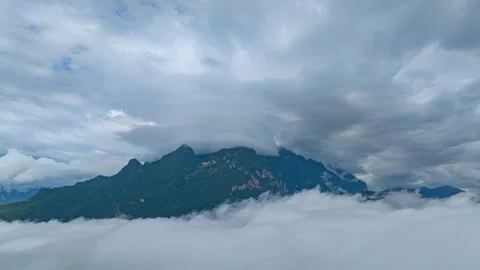 Hyper lapse Arial view of Mist drifts over the towering Doi Luang Chiang Dao. Stock Footage 295998894
