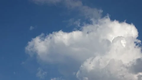 Hyper lapse of beautiful white fluffy clouds moved by the wind in a blue sky Stock Footage 138276267