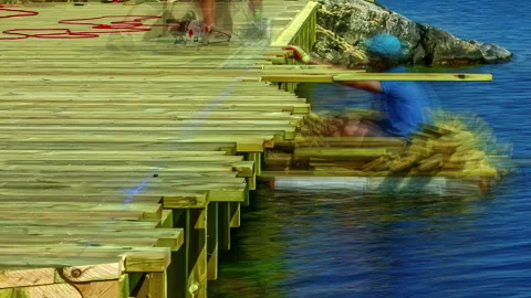 Hyper lapse of builders building a wooden deck on water using tools Stock Footage 256278614