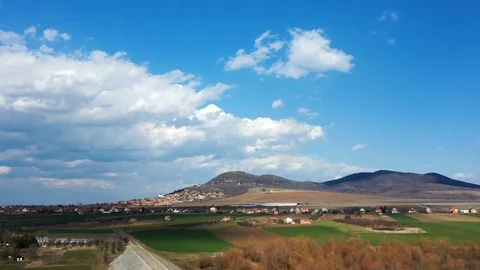 Hyper lapse of a city under a hill with blue skies and clouds Stockbeeldmateriaal 125527517