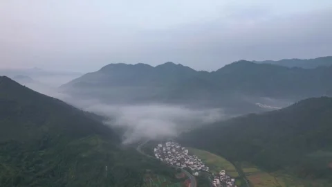 Hyper lapse drone view of villages and farmlands among green mountain valley Stock Footage 285195626