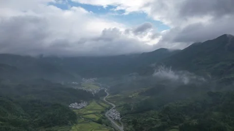 Hyper lapse drone view of villages and farmlands among green mountain valley Stock Footage 285196882