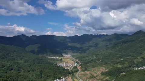Hyper lapse drone view of villages and farmlands among green mountain valley Stock Footage 285197778
