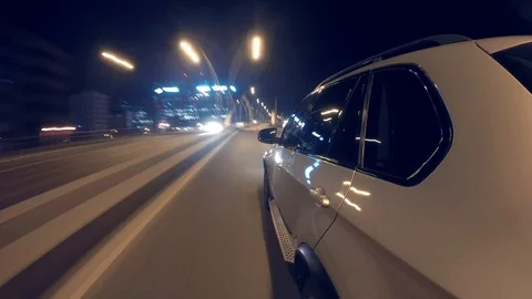 Hyper-lapse from a moving luxury car driving on a city street at night Stock Footage