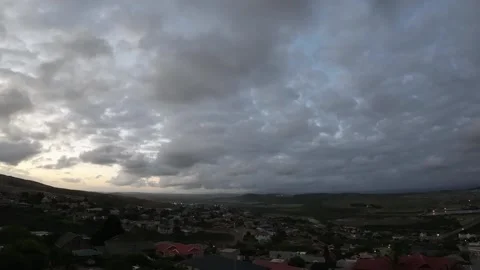 Hyper Lapse of rolling clouds over head towards mountains day to night Stock Footage 260374245