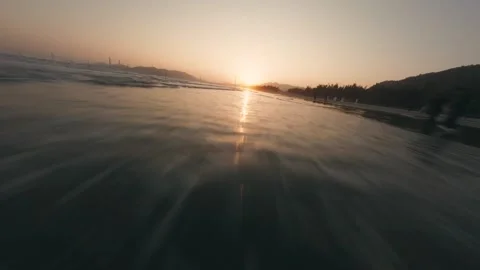 Hyper-Lapse Shot of Water Rushing Across Sandy Beach During Golden Sunset Stock Footage 319295195