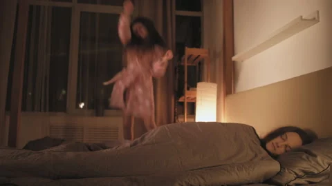 Hyperactive child tired mom sleeping girl dancing Stock Footage 131458840
