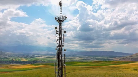 Hyperlapse around telecommunication tower in front of agricultural field and 스톡 동영상 303613792
