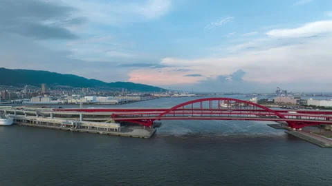 Hyperlapse: Cars move over red arched bridge next to ferry terminal Stock Footage 206204852