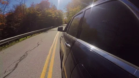 HYPERLAPSE: SUV car driving on empty forest road on gorgeous sunny day in autumn Stock Footage 80033684