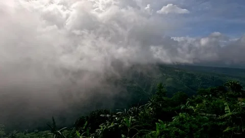 Hyperlapse of thunderous clouds rolling over a vast, mist-covered rainforest Stock Footage 326083628