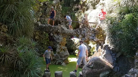Hyperlapse of tourists stepping on rocks in pond Stock Footage 118659473