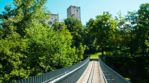 Hyperlapse towards Brunico Castle in summer passing over a Tibetan bridge Video stock 98859774