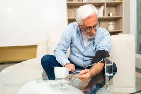 Hypertension problem in senior age. Old man measuring blood pressure with Stock Photos