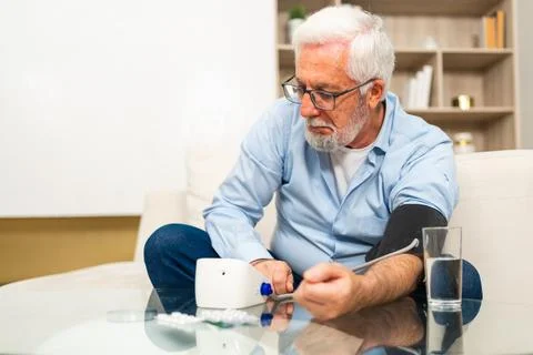 Hypertension problem in senior age. Old man measuring blood pressure with Stock Photos