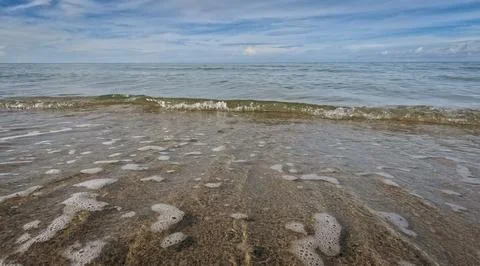 Hypnotic frothy waves lapping at the shore  Stock Photos
