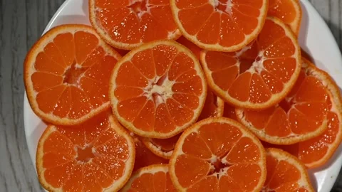 Hypnotic Mandarin Slices Spin. Seamless 4K Abstract Citrus Background Loop Stock Footage 325740864