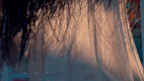The hypnotic movement of a lightweight beach cabana canopy flutters Stock Footage 322511915