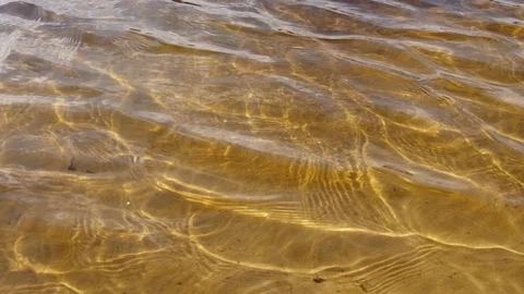 Hypnotic repeating yellow water waves. Bright sunny day. Summer. Sand river bed Video stock 119447745