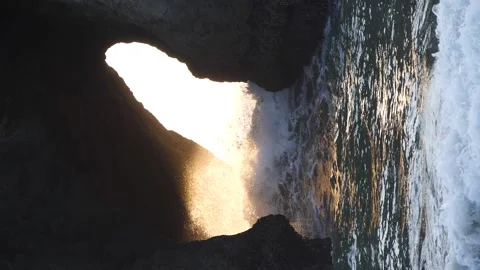 A hypnotic slow-motion shot of a splash in a cave with golden light Video stock 166432360