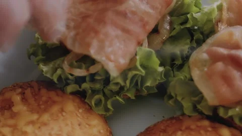 I add the bacon from the grill to the green tomato burger ingredients Stock Footage 257577106