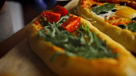 I add cherry tomatoes to the vegetarian pide. Vegetarian pide pide with egg and Stock Footage 157298631
