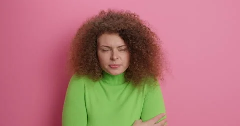 I am freezing. Curly haired young woman hugs herself trembles from cold asks to Stock Footage 154732229