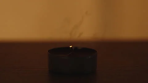 I blow out a Red Round Candle on a Wooden Table, close-up. A light flickers in t Vídeos de archivo 233162523