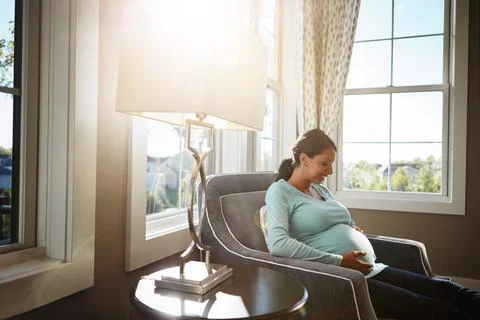 I can hardly wait for you to enter the world. a pregnant woman sitting in her Stock Photos