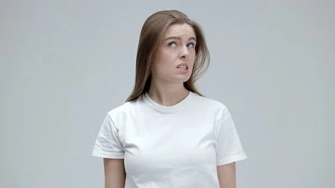 I do not know. An embarrassed woman with long, straight hair in a T-shirt rai Stock Footage 167303828