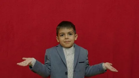 I dont know gesture of cute boy isolated on read. Uncertainty and risk in Stock Photos