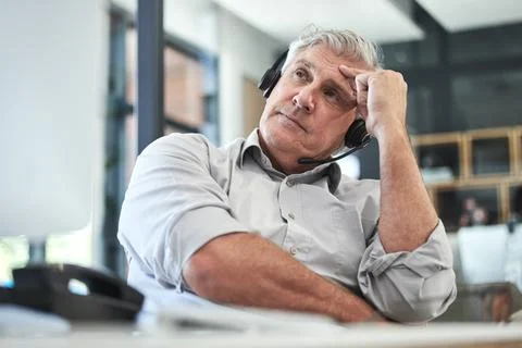 I dont know what to do. a mature call centre agent sitting alone in the office Stock Photos