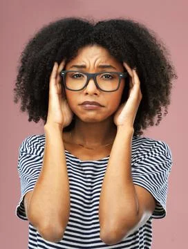 I dont know what to do. a young woman suffering from a headache against a pink Stock Photos