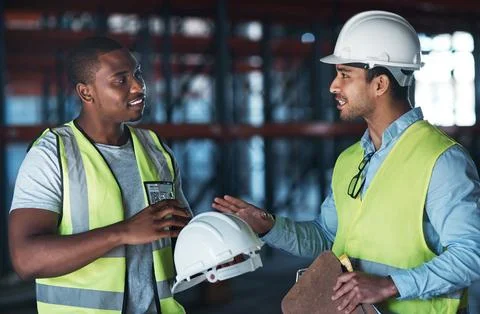 I dont want any problems. Shot of two young contractors standing in the Stock Photos