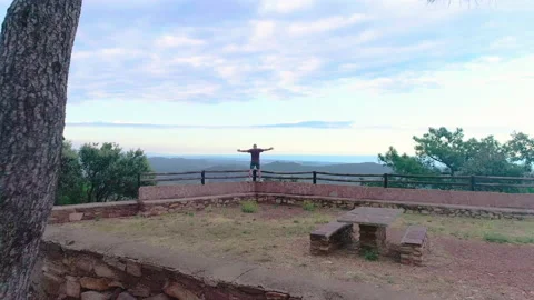 I fly from behind the drone towards a man looking out to the infinite Stock Footage 138895998