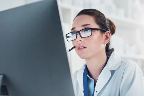 I have to study hard on this case. a focused young female scientist working on a Stock Photos