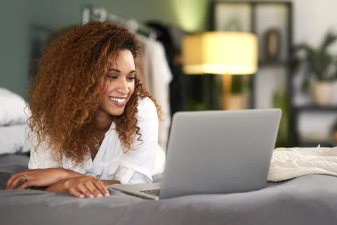I hope this e-mail finds you well, it does. a young woman using her laptop while Stock Photos