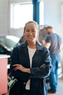 I know my way around a toolbox. a female mechanic posing with her arms crossed Stock Photos