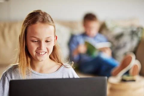 I learn through technology while my brother prefers books. an adorable little Foto stock