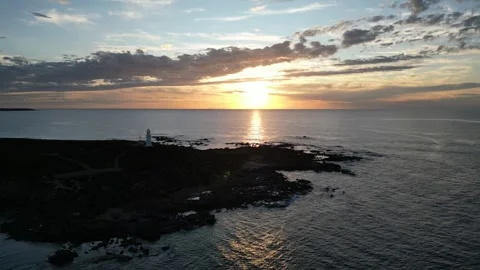 I lighthouse at the ocean, during sunset. It's like a Trinity for epic videos. Stock Footage 313171453