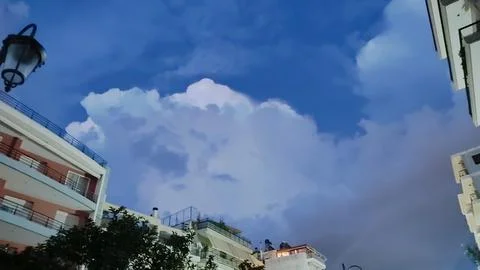 As I look up at the cloudy sky above, I see buildings in the foreground Foto stock