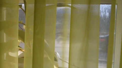 I look out the window through the curtain Stock Footage 106013982