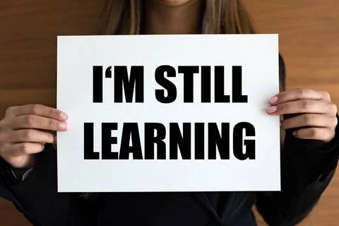  I m still learning I m still learning. Woman with white page, black lette... Stock Photos