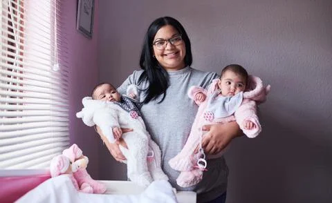 I made a wish, it came true twice. a young woman carrying her twin baby girls at Stock Photos