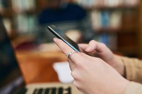 I never go anywhere without it. an unrecognizable student using her cellphone. Stock Photos
