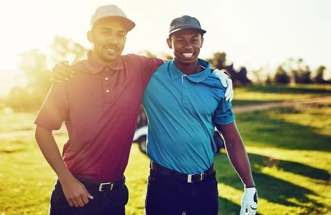 I prefer golfing with a buddy. two friends standing together on a golf course. 스톡 사진