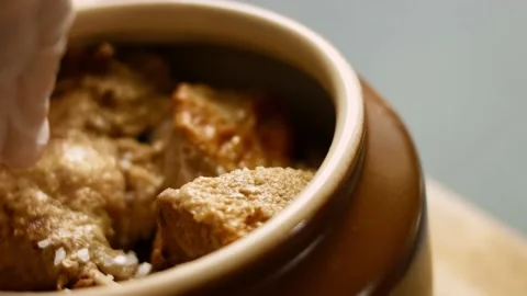 I press salt over the chickpea duck. The duck gives steam and looks very Stock Footage 156448957