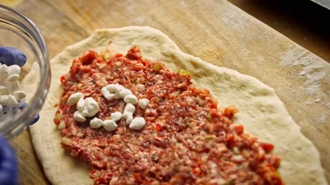 I put the cottage cheese over the pide. We prepare pide with salami. 4k video Stock Footage 157297653
